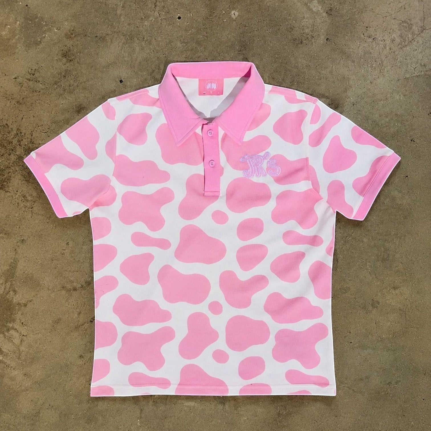 JR's Strawberry Milk polo shirt in pink and white cow print pique knit with embroidered logo detail.