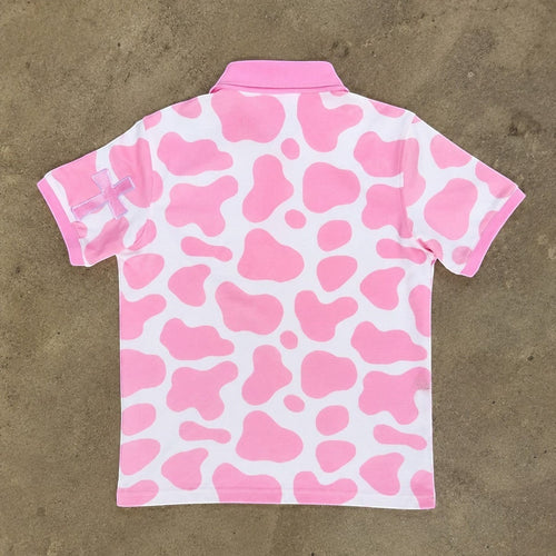 JR's Strawberry Milk polo shirt in pink and white cow print pique knit with embroidered cross detail on the sleeve.